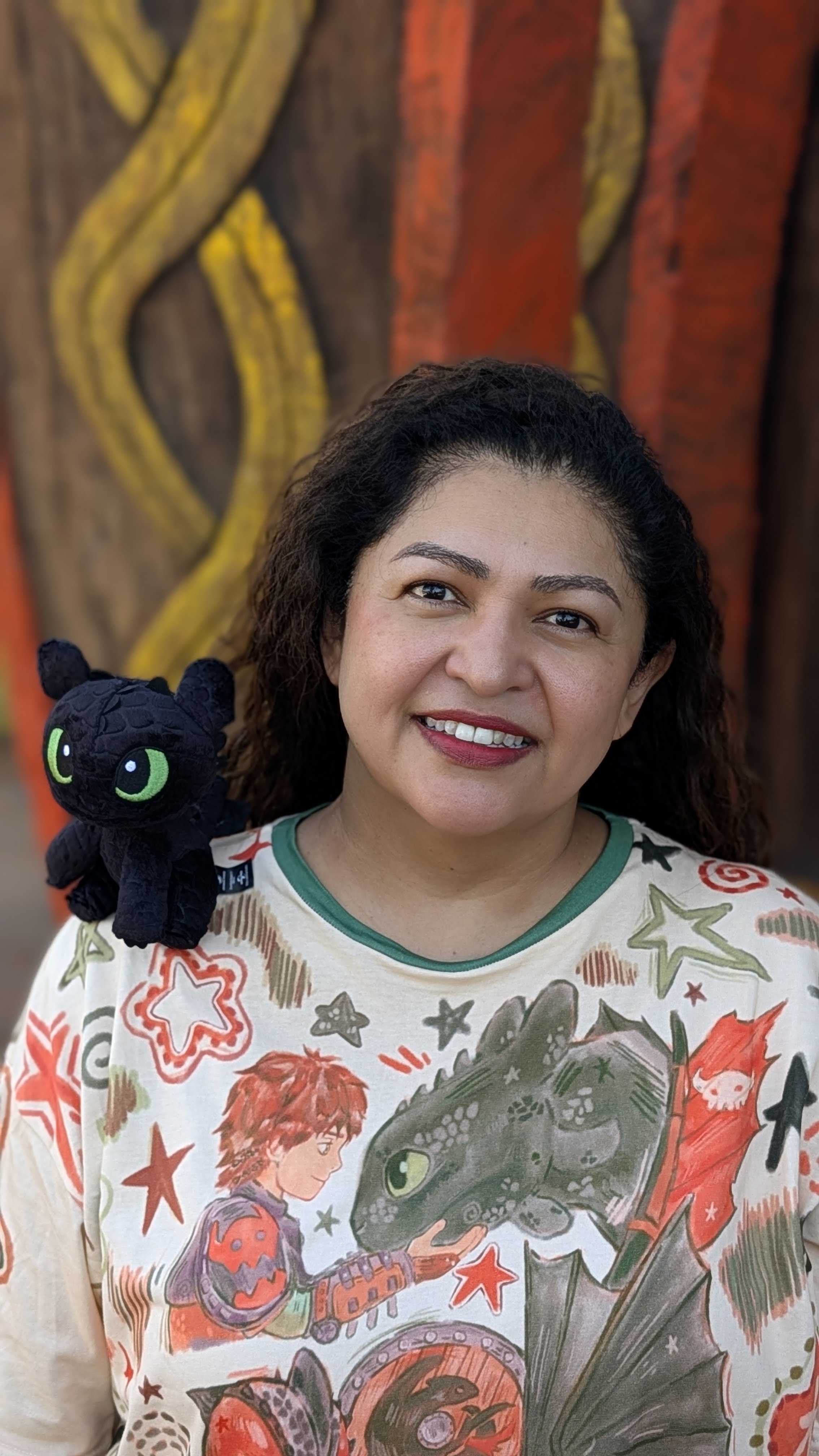 Aura smiling with a playful plush companion